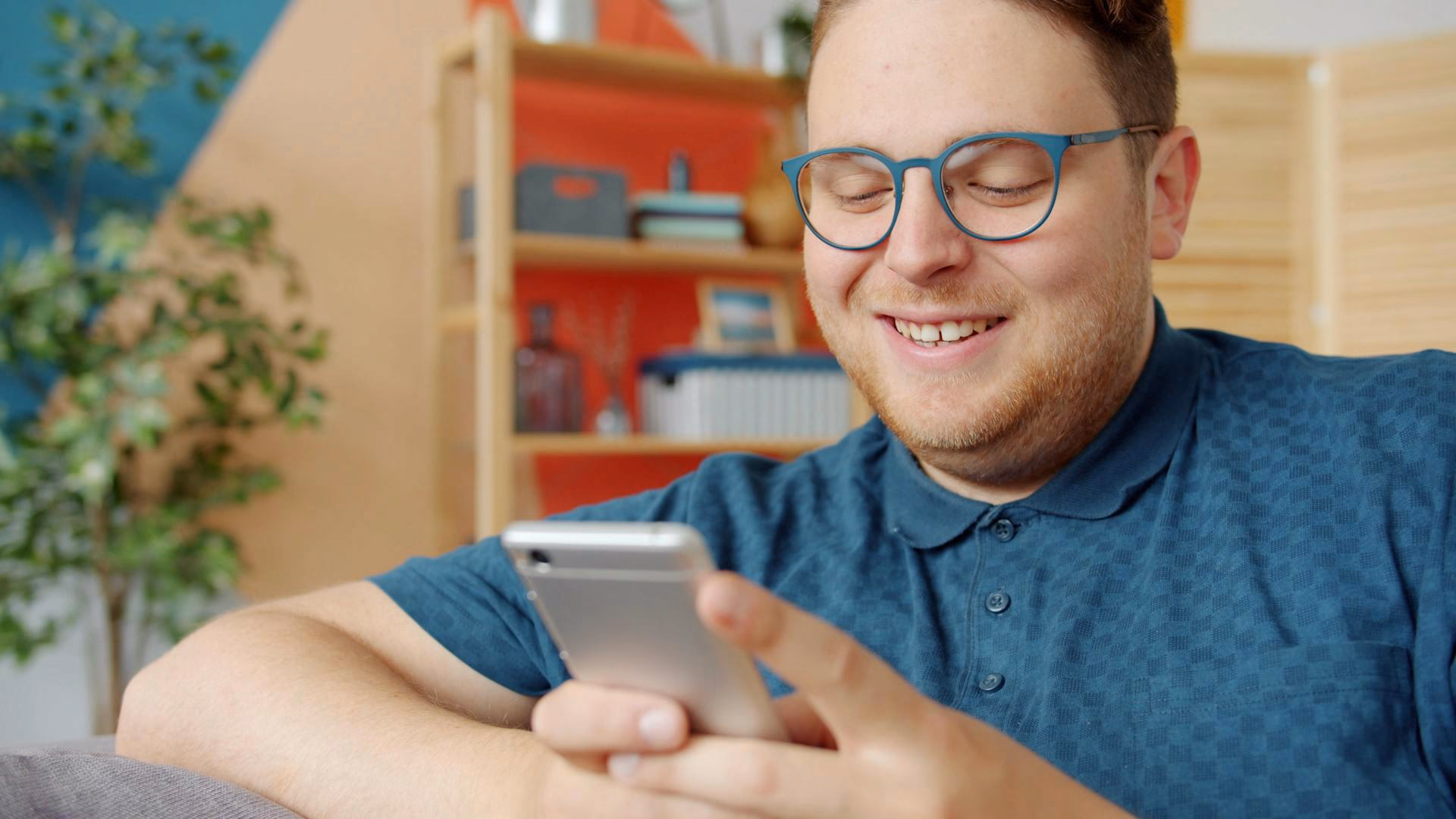a person smiling and using his mobile phone